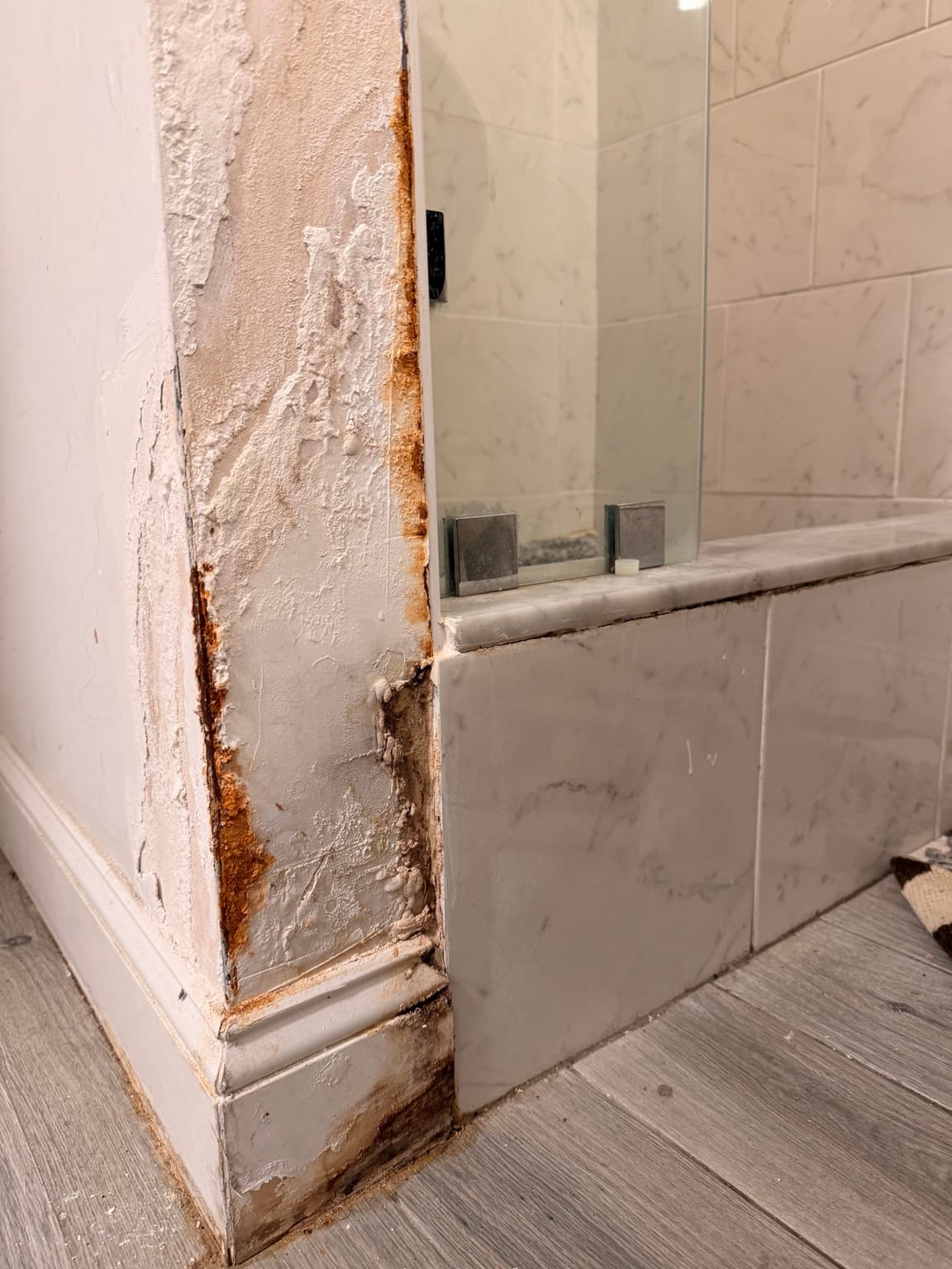 Rust and moisture damage at bathroom trim and wall corner