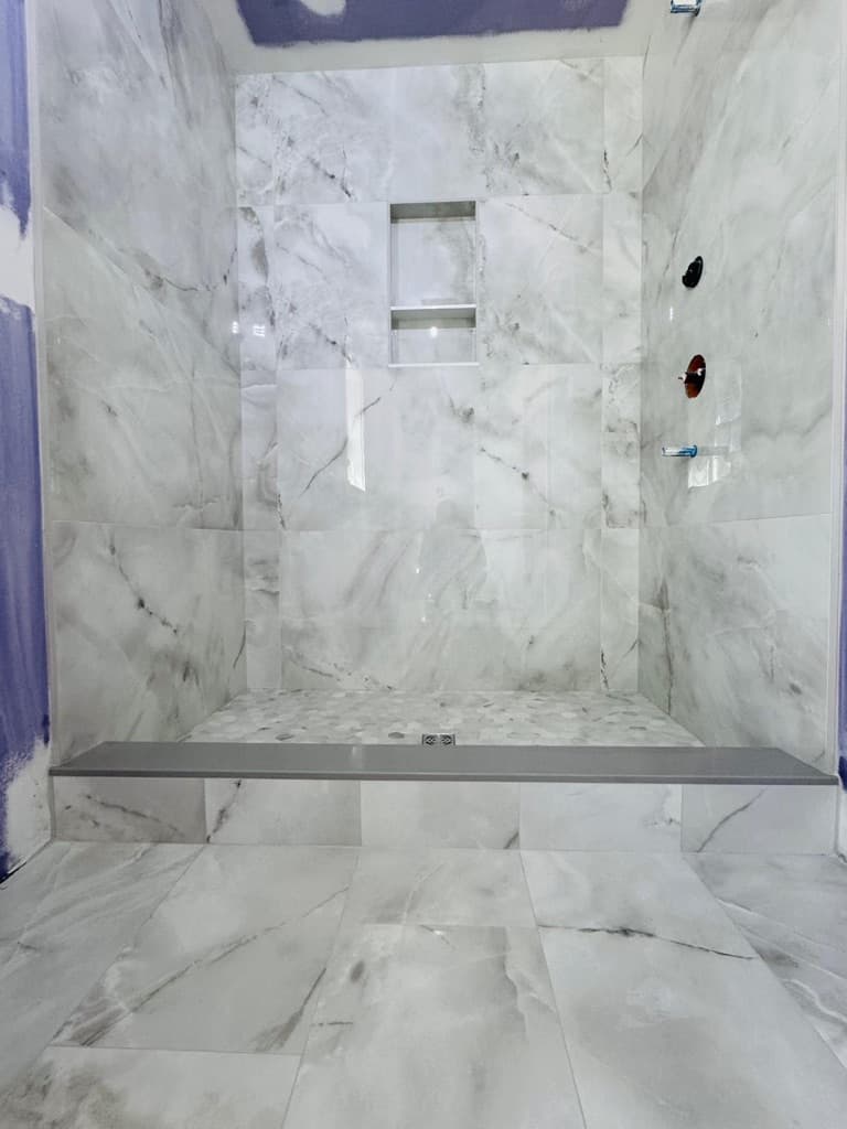 Completed marble shower showing resolved layout and finish