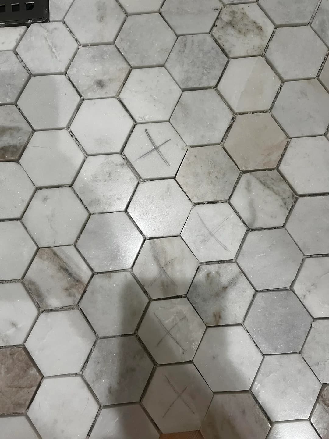 Marble hex tile floor with inconsistent material selection and markings